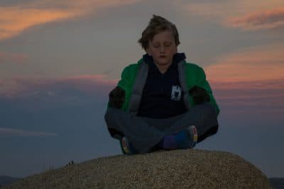 meditating child on mountain peak Internal Retreat